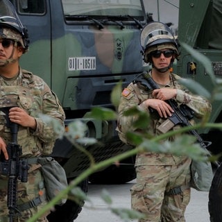 Zwei Soldaten der Nationalgarde stehen in Los Angeles mit Waffen vor einem Militärfahrzeug