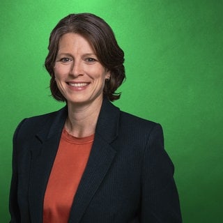 Bettina Iseli, Vorstand Welthungerhilfe, lächelt vor einer grünen Wand in die Kamera.
