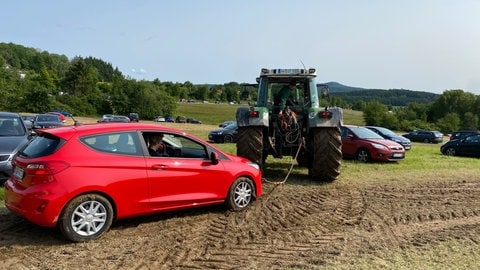 Einige Autos müssen mit Traktoren aus dem Schlamm gezogen werden