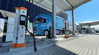 Ein langer E-Lkw steht an einer Ladesäule auf dem TST-Gelände